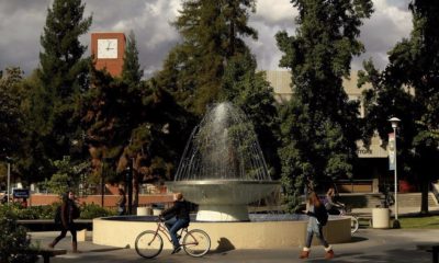 Students walk and cycle past the centerpiece fountain at Fresno State