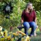 Photo of Heather Melton sitting by the grave of her late husband, Sonny Melton