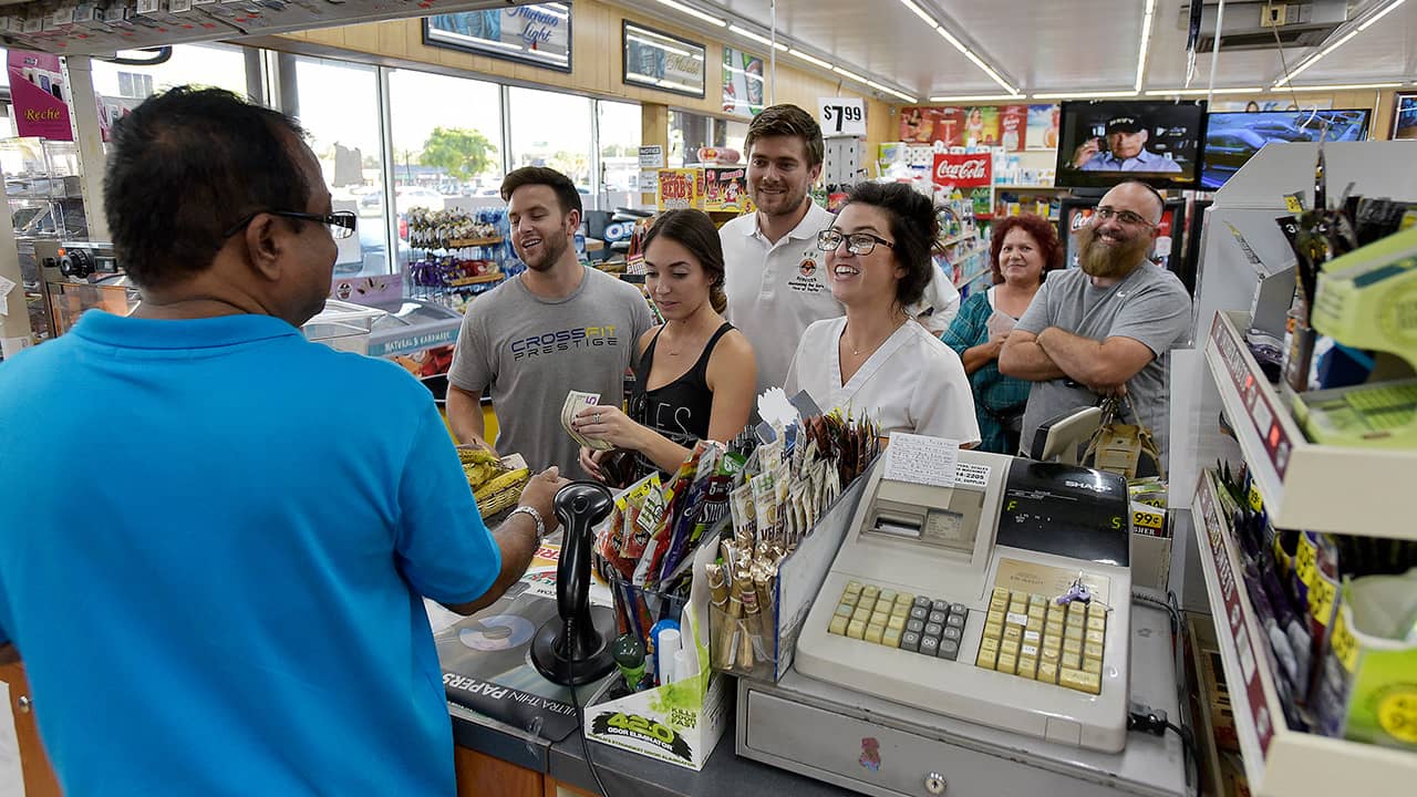 Photo of people lining up at a store to buy lottery tickets