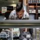 Photo of Jerred Kiloh stocking shelves with cannabis products