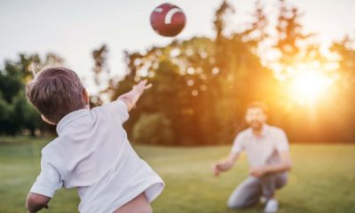 Photo of a son throwing a football to his dad