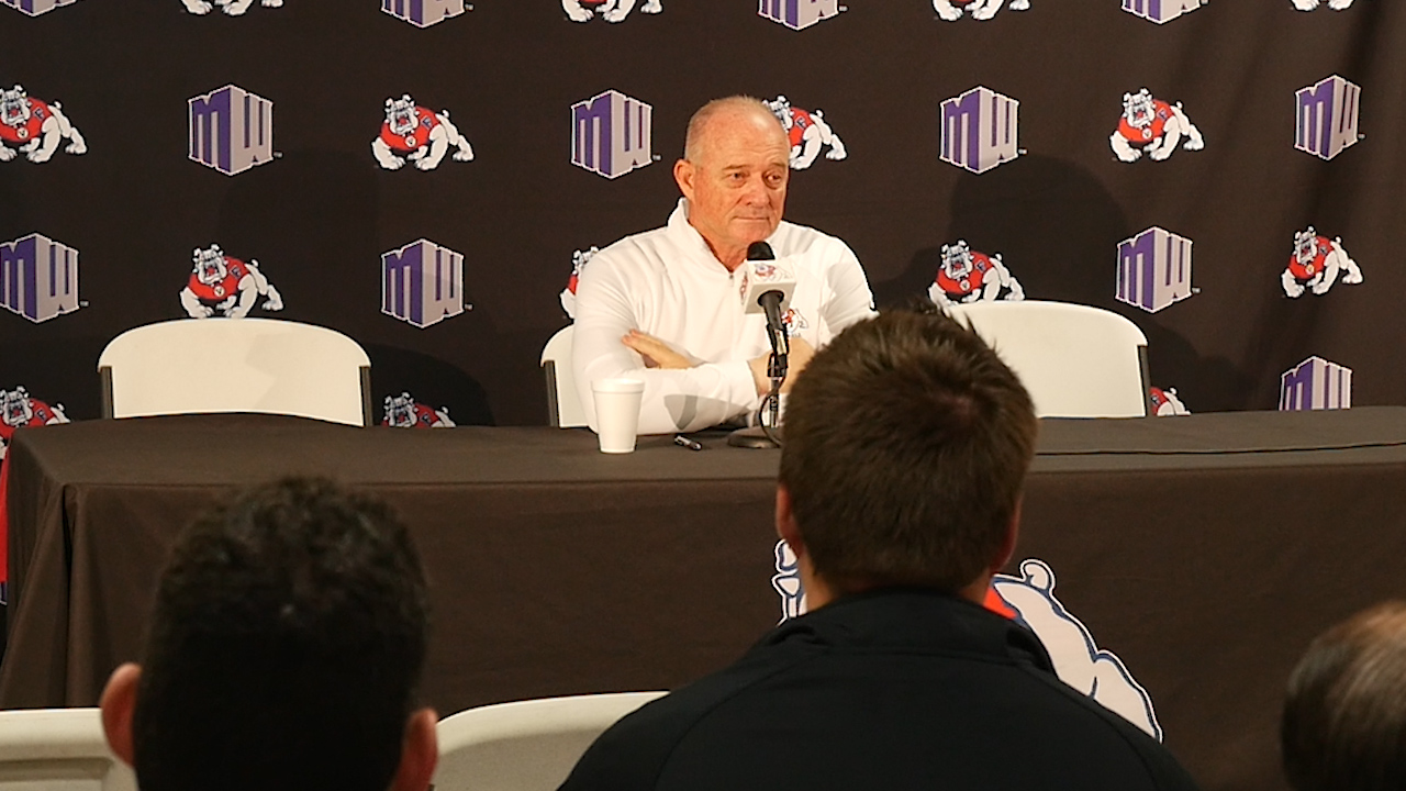 Photo of Jeff Tedford sitting at a table and talking to the media.