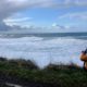 Photo of a man photographing waves crashing onto the cliffs at Rodea Point in Lincoln County, Ore.