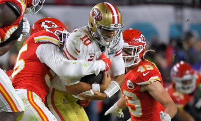 Photo of Kansas City Chiefs' Frank Clark, left, trying to tackle San Francisco 49ers' quarterback Jimmy Garoppolo