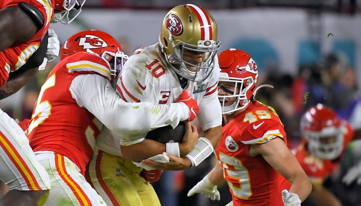 Photo of Kansas City Chiefs' Frank Clark, left, trying to tackle San Francisco 49ers' quarterback Jimmy Garoppolo