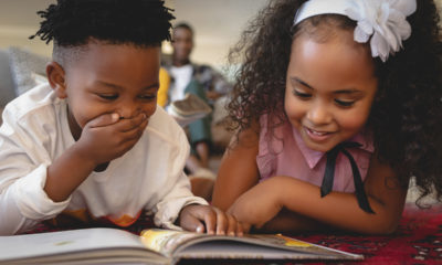 Image of two young African American students reading together