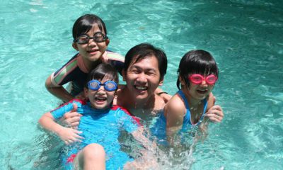 Photo of a dad with his children in a swimming pool on Father's Day