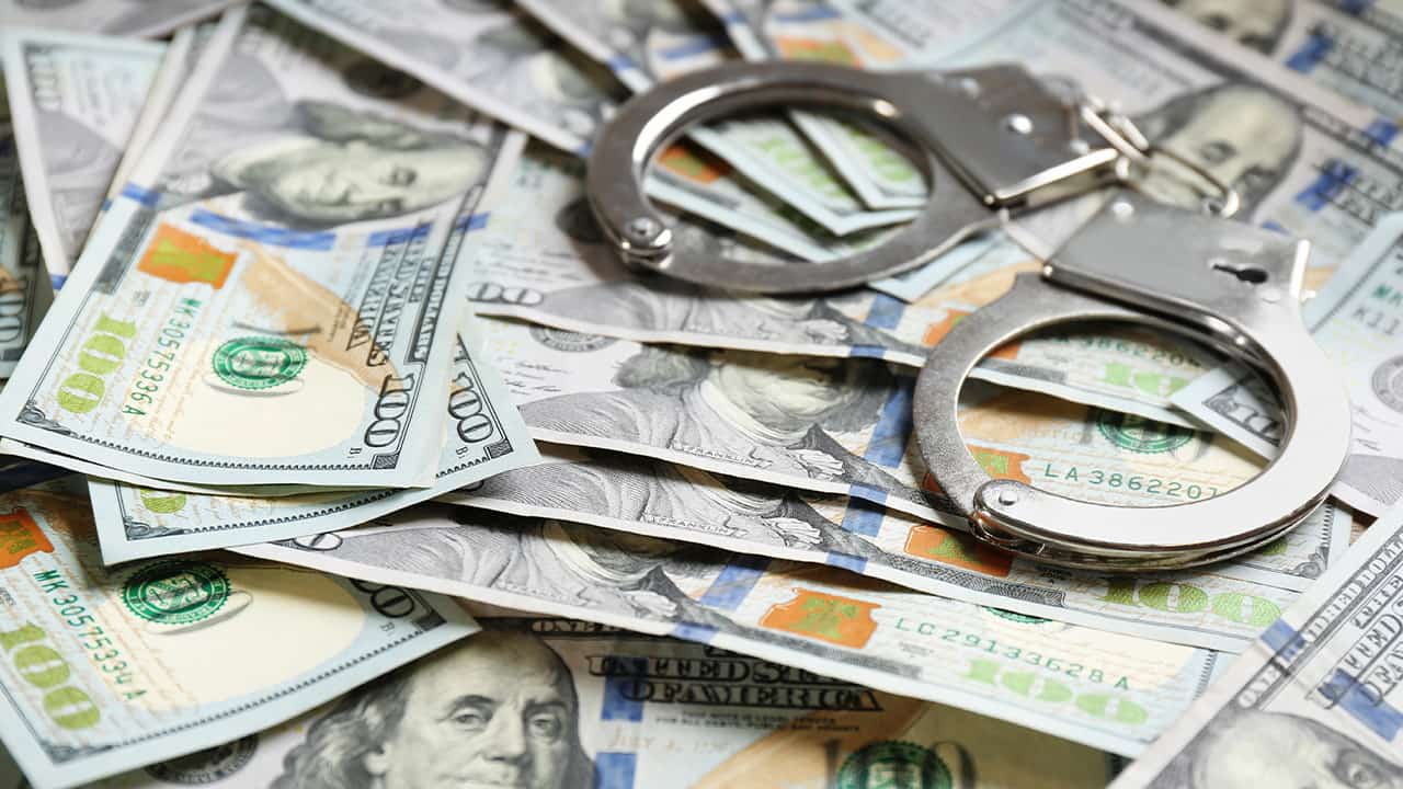 Photo of handcuffs and $100 bills signifying reward money for catching escapes inmates